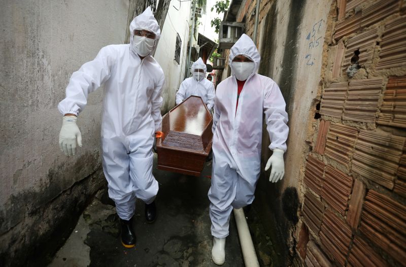 &copy; Reuters. Agentes funerários carregam caixão de vítima de Covid-19 em Manaus
