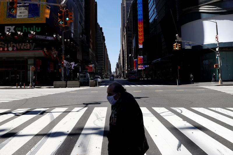 &copy; Reuters. A man crosses 7th Avenue in nearly deserted Times Square during the outbreak of the coronavirus disease (COVID-19) in New York