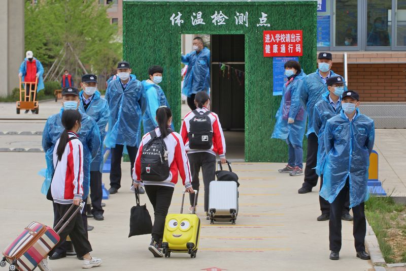 &copy; Reuters. Agentes de policía con mascarillas vigilan la entrada a un colegio en Yantai, China.
