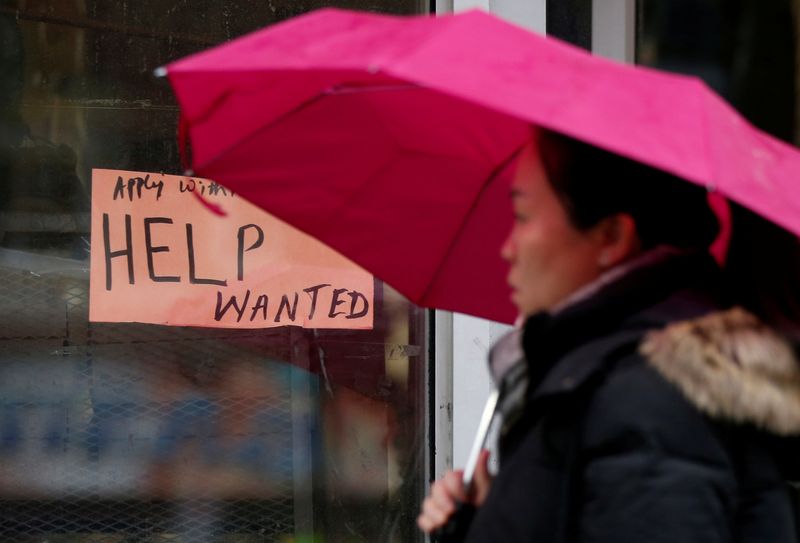 &copy; Reuters. FILE PHOTO: A woman walks past a &quot;Help wanted&quot; sign at a retail store in Ottawa