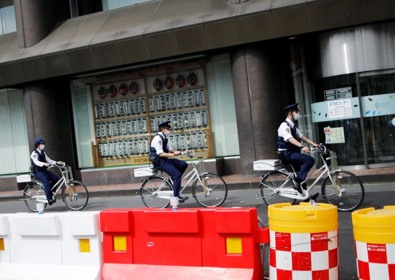 © Reuters. Police officers wearing protective face masks ride bicycles on the street under a nationwide state of emergency as the spread of the coronavirus disease (COVID-19) continues in Tokyo