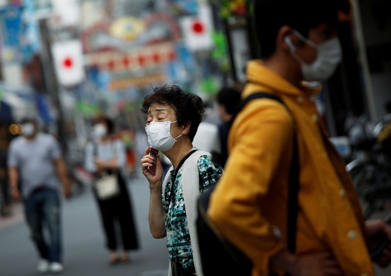 &copy; Reuters. People wearing protective face masks walk on the street under a nationwide state of emergency as the spread of the coronavirus disease (COVID-19) continues in Tokyo