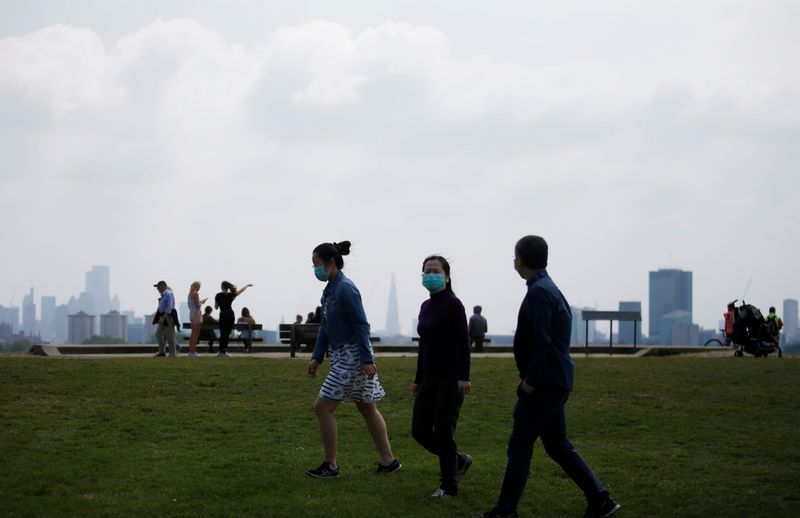 © Reuters. Gente en Primrose Hill usando mascarillas, en Londres