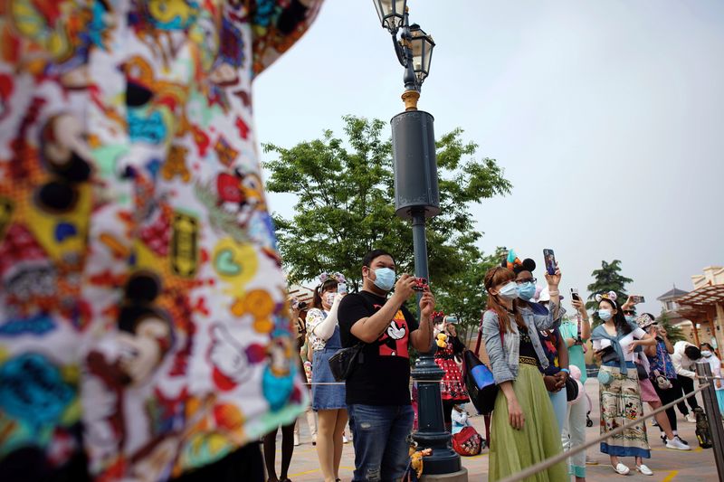 © Reuters. Visitors take pictures at the ceremony marking the reopening of Shanghai Disneyland