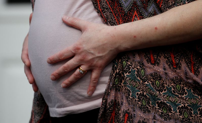 © Reuters. FILE PHOTO: Stephanie Bowers who is 8 months pregnant poses for a photograph outside her home, as the spread of the coronavirus disease (COVID-19) continues, Manchester