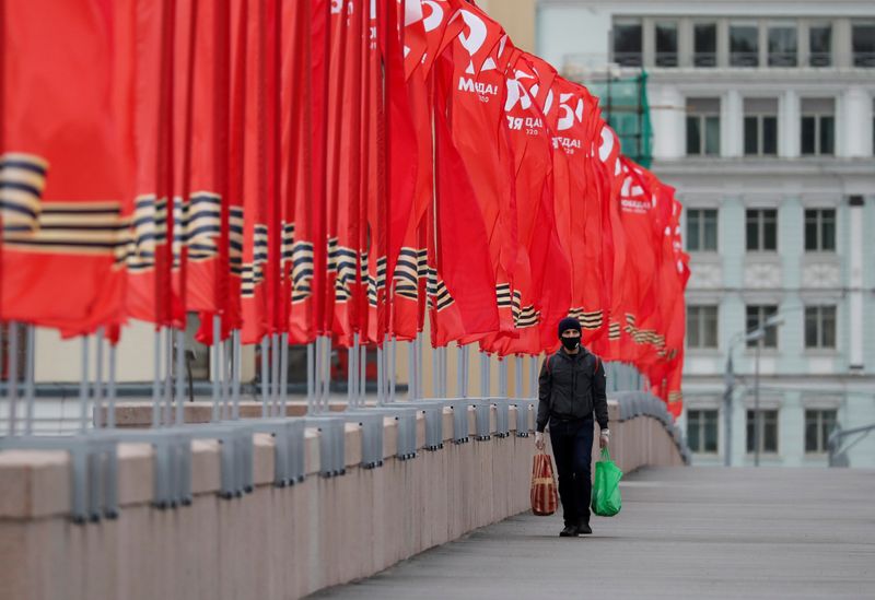 &copy; Reuters. A man walks along a bridge past flags prepared for the celebrations of the Victory Day in Moscow
