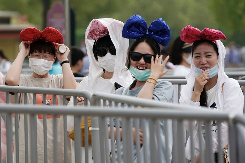&copy; Reuters. Visitantes com máscaras de proteção na Dysneylândia de Xangai