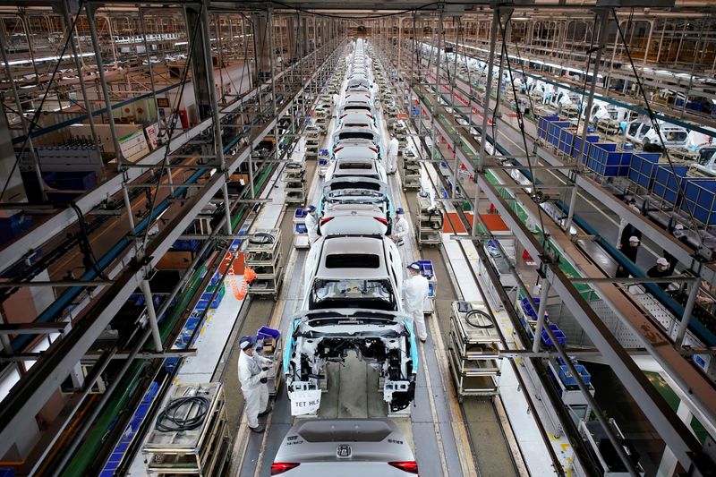 © Reuters. FILE PHOTO: Employees work on a production line inside a Dongfeng Honda factory in Wuhan