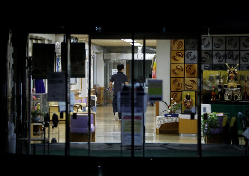 &copy; Reuters. A staff member is seen inside an elderly care home where according to local media more than 40 residents and staff members have been infected with the coronavirus disease (COVID-19), in Tokyo