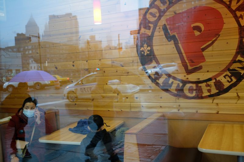 &copy; Reuters. Woman sits at the Chinatown Popeyes location with a face mask in New York City