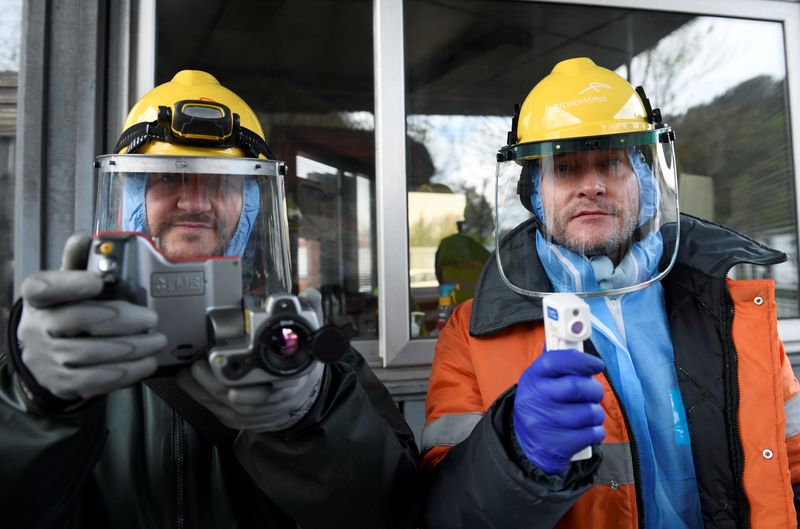 &copy; Reuters. FILE PHOTO: Workers from the multinational ArcelorMittal pose with a thermal camera and a digital thermometer with which they use to take the temperature of personnel entering a factory, to help combat the spread of the coronavirus disease (COVID-19) in G