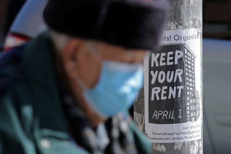 &copy; Reuters. FILE PHOTO: Elderly man passes a sign publicizing a rent strike during the global outbreak of coronavirus disease in Toronto