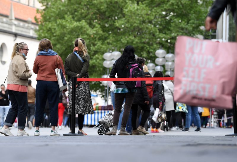&copy; Reuters. Consumidores aguardam em fila em Munique após afrouxamento da quarentena da Covid-19 na Alemanha