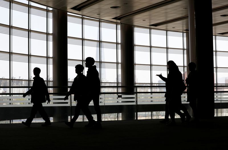 &copy; Reuters. University students walk during a job fair in Seoul, South Korea