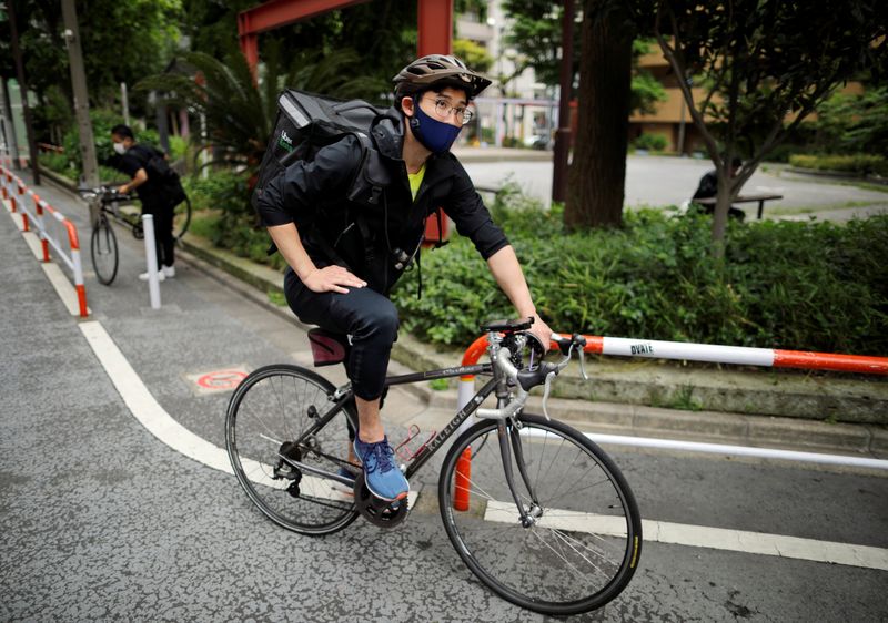 &copy; Reuters. Japan&apos;s Olympic fencing medallist Ryo Miyake cycles as he works his part-time job as Uber Eats delivery person as the spread of the coronavirus disease (COVID-19) continues in Tokyo