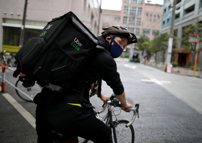 © Reuters. Japan's Olympic fencing medallist Ryo Miyake cycles as he works his part-time job as Uber Eats delivery person as the spread of the coronavirus disease (COVID-19) continues in Tokyo