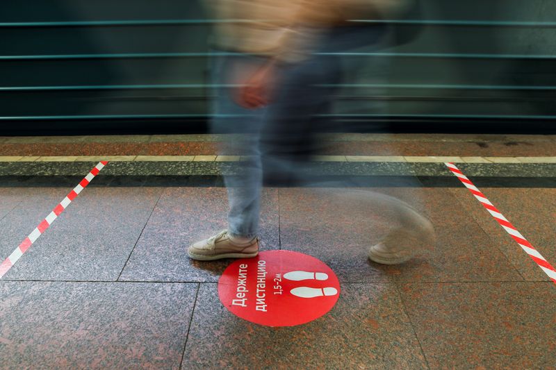 &copy; Reuters. Знак, предупреждающий о необходимости соблюдать социальную дистанцию, на станции метро в Москве