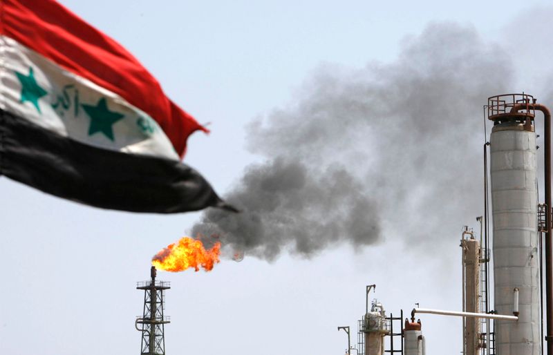 © Reuters. Флаг Ирака на фоне НПЗ в Басре