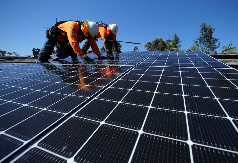 &copy; Reuters. FILE PHOTO: Solar installers from Baker Electric place solar panels on the roof of a residential home in Scripps Ranch, San Diego, California