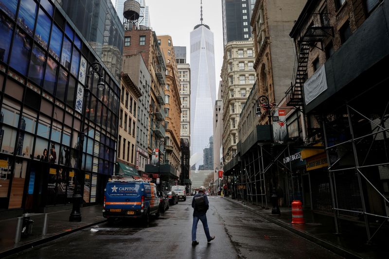 © Reuters. FILE PHOTO: A man crosses a nearly deserted Fulton Street in the financial district of lower Manhattan in New York