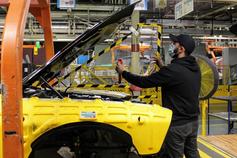 © Reuters. An operator at FCA's Brampton Assembly Plant installs a removable plexiglas partition in the engine compartment of a Dodge Challenger