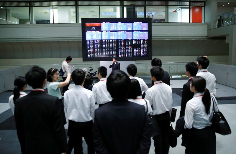 &copy; Reuters. Dei visitatori controllano le quotazioni di borsa su uno schermo elettronico della Borsa di Tokyo a Tokyo