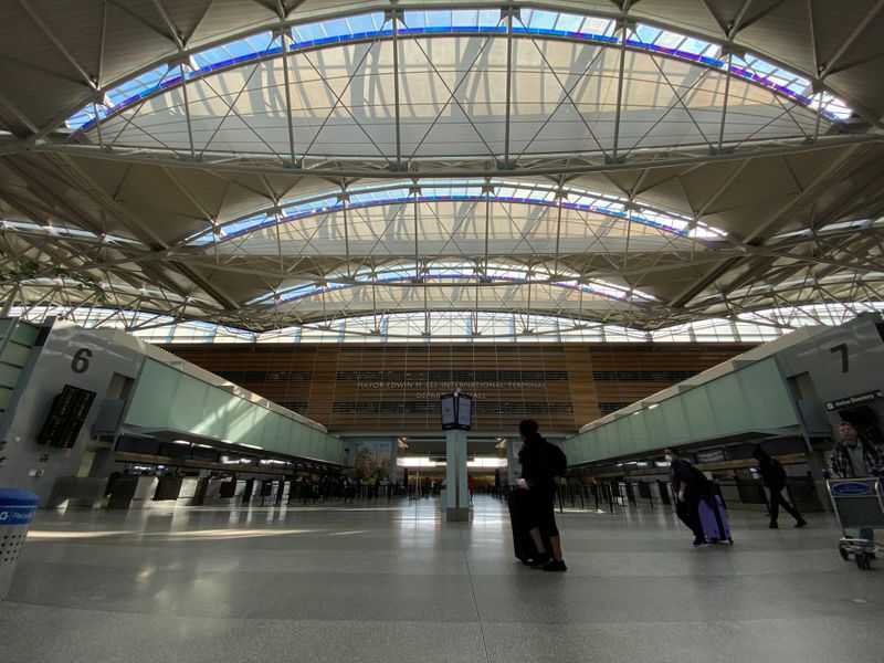 © Reuters. FILE PHOTO: A view of a handful of travellers, many in protective masks amid coronavirus disease (COVID-19) outbreak, at the departures hall of the San Francisco International Airport in San Francisco