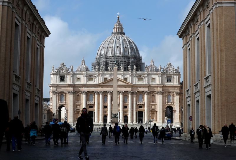 &copy; Reuters. FILE PHOTO: People walk on St. Peter&apos;s Square after the Vatican reports its first case of coronavirus