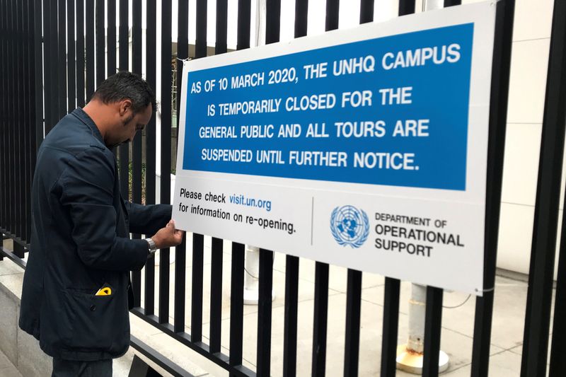 © Reuters. FILE PHOTO: A worker erects a sign informing people that the United Nations Headquarters will be temporarily closed for tours due to the spread of coronavirus in the Manhattan borough of New York City