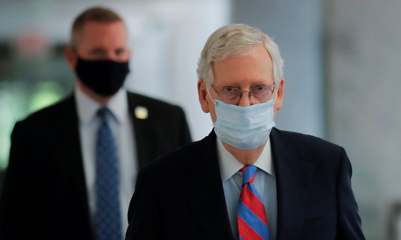 &copy; Reuters. El líder de la mayoría del Senado de EEUU, Mitch McConnell, usa una mascarilla mientras camina por un pasillo del Senado durante el brote de coronavirus en Capitol Hill, en Washington. 12 de mayo de 2020.