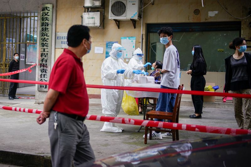 &copy; Reuters. Medical workers in protective suits conduct nucleic acid testings for residents at a residential compound in Wuhan