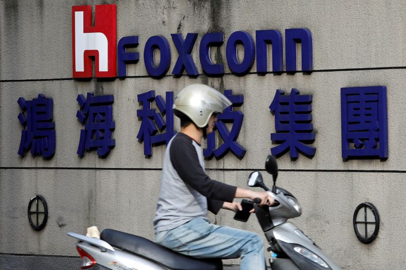 &copy; Reuters. FILE PHOTO: A motorcyclist rides past the logo of Foxconn, the trading name of Hon Hai Precision Industry, in Taipei