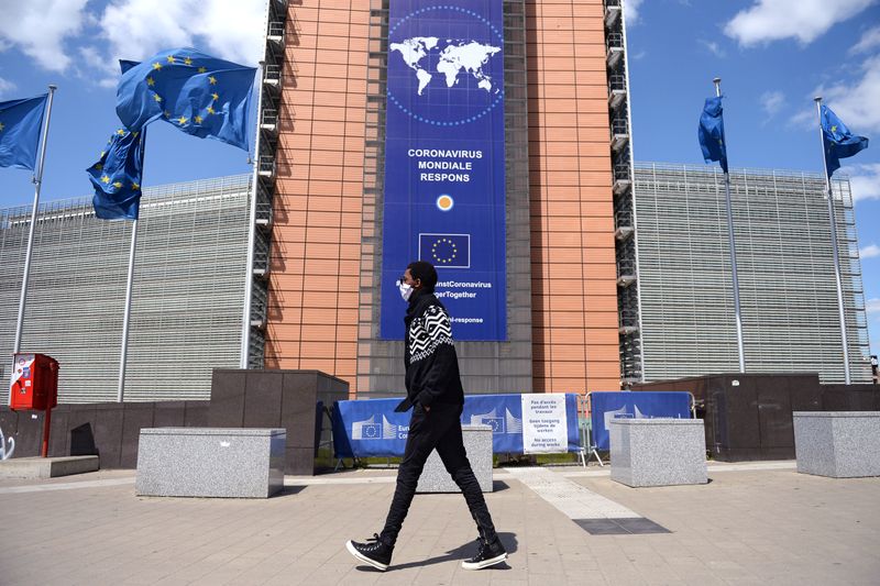 &copy; Reuters. FILE PHOTO: A man wearing a face mask walks past the European Commission headquarters as the spread of coronavirus disease (COVID-19) continues in Brussels