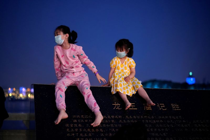 &copy; Reuters. Dos niñas con mascarillas en Wuhan