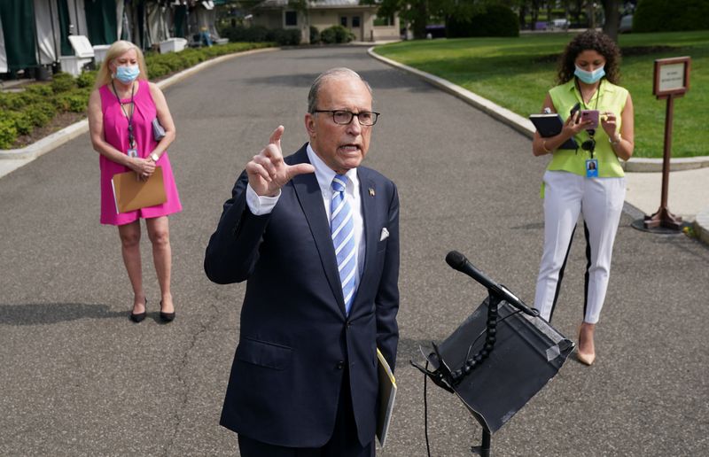 &copy; Reuters. Asesores con mascarillas se ubican detrás del asesor económico de la Casa Blanca, Larry Kudlow, mientras habla con periodistas sobre el impacto económico de la enfermedad COVID-19 en la Casa Blanca, en Washington. 15 de mayo de 2020.