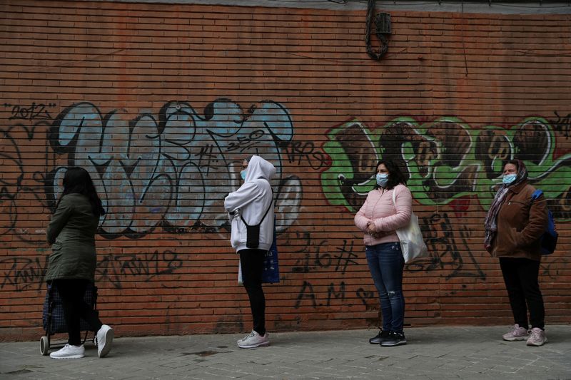 &copy; Reuters. People queue to receive donated food from volunteers of Vecinos Parque Aluche association as the spread of the coronavirus disease (COVID-19) continues in Madrid