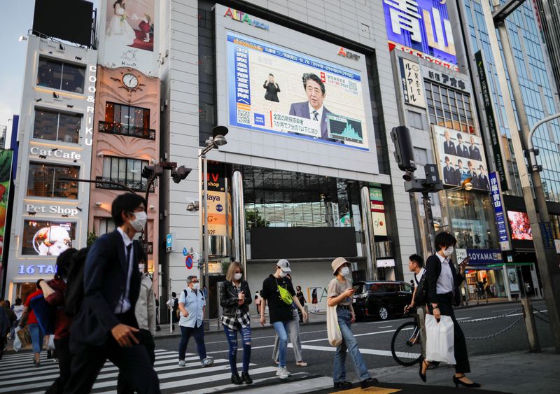 &copy; Reuters. Прохожие в масках в районе Токио Синдзюку во время пандемии COVID-19