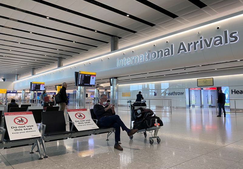 &copy; Reuters. Las personas se sientan entre carteles en el aeropuerto de Heathrow en Londres, Reino Unido, el 10 de mayo de 2020
