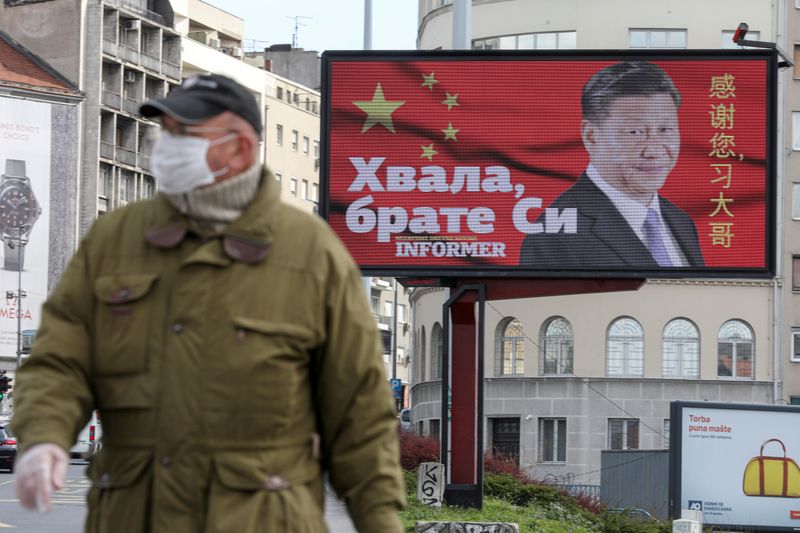 &copy; Reuters. FOTO DE ARCHIVO: Un hombre con una máscara protectora pasa por un cartel que muestra al presidente chino Xi Jinping en Belgrado, Serbia, el 1 de abril de 2020. REUTERS/Djordje Kojadinovic