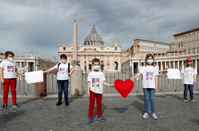 &copy; Reuters. Los niños de la escuela polaca de Roma usan máscarillas para celebrar el cumpleaños del difunto Papa Juan Pablo II, durante el brote de la enfermedad coronavirus (COVID-19), en el Vaticano, el 18 de mayo de 2020