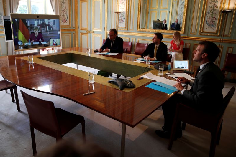 © Reuters. El presidente francés Emmanuel Macron escucha a la canciller alemana Angela Merkel durante una videoconferencia en el Palacio del Elíseo, París, Francia.