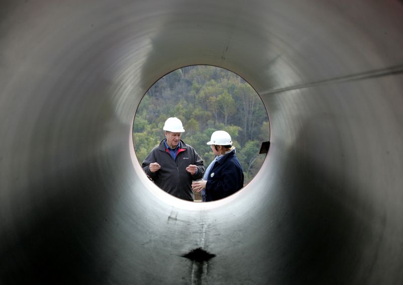 &copy; Reuters. FILE PHOTO: Engineers talk standing next to pipes at a pipeline building site of the Sakhalin-2 project north of Yuzhno-Sakhalinsk