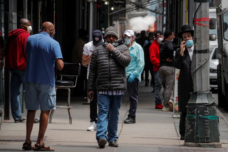 &copy; Reuters. Прохожие в масках на улицах Нью-Йорка во время эпидемии COVID-19