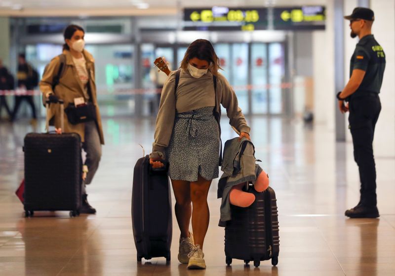 &copy; Reuters. FOTO DE ARCHIVO: Una mujer con una mascarilla llega al aeropuerto Josep Tarradellas Barcelona-El Prat