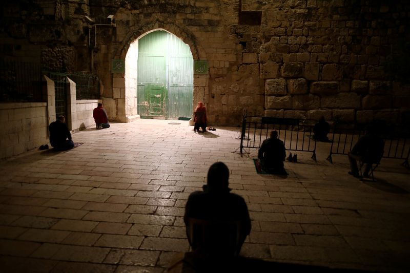 &copy; Reuters. FILE PHOTO: Muslim worshippers pray near the closed gate of the compound housing Al-Aqsa mosque as mosques were closed due to the coronavirus disease (COVID-19) around the country