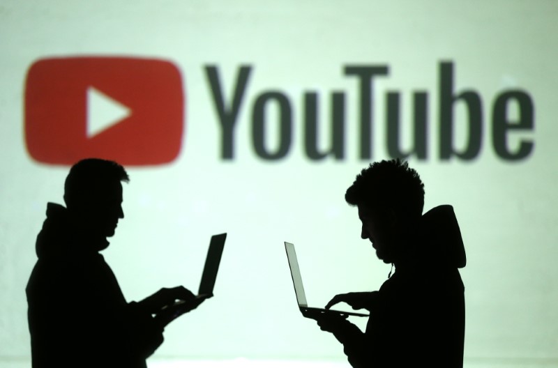 &copy; Reuters. Silhouettes of mobile device users are seen next to a screen projection of Youtube logo in this picture illustration