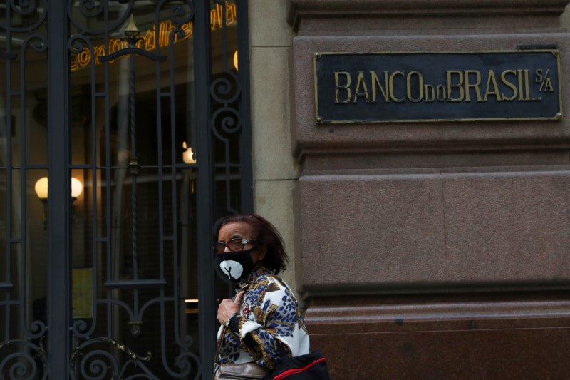 &copy; Reuters. Mulher usa máscara de proteção em frente a agência do Banco do Brasil em São Paulo
