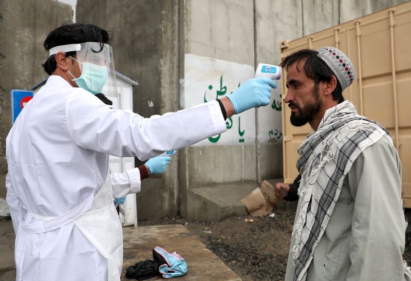 &copy; Reuters. FILE PHOTO:  Medical official checks body temperature of traveller in Kabul