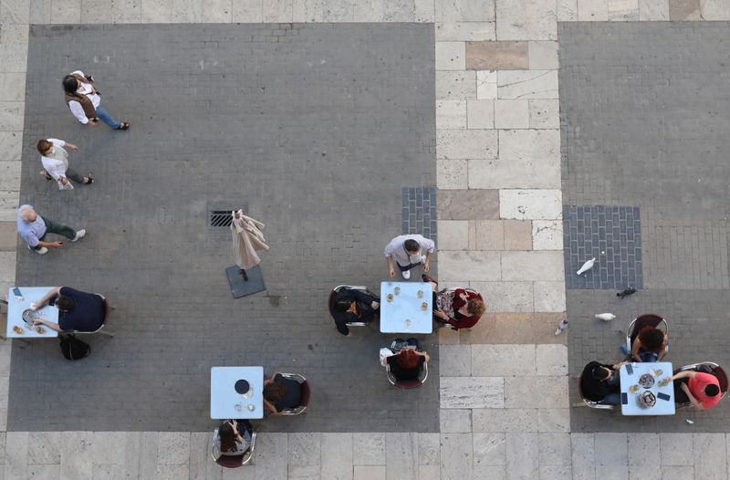 &copy; Reuters. Personas sentadas en la terraza de un bar, después que en algunas provincias españolas han relajado las restricciones de cierre durante la primera fase en Valencia, España, el 18 de mayo de 2020