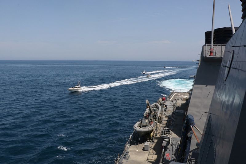 © Reuters. Four Iranian Islamic Revolutionary Guard Corps Navy vessels alongside U.S. Naval Forces in the Gulf